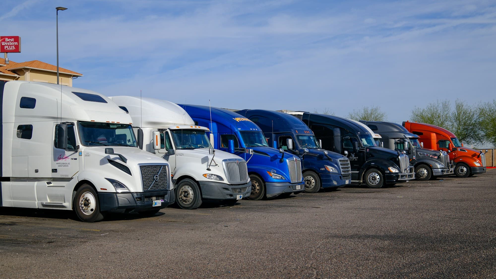 A line of heavy tractor trailers at a freight stop